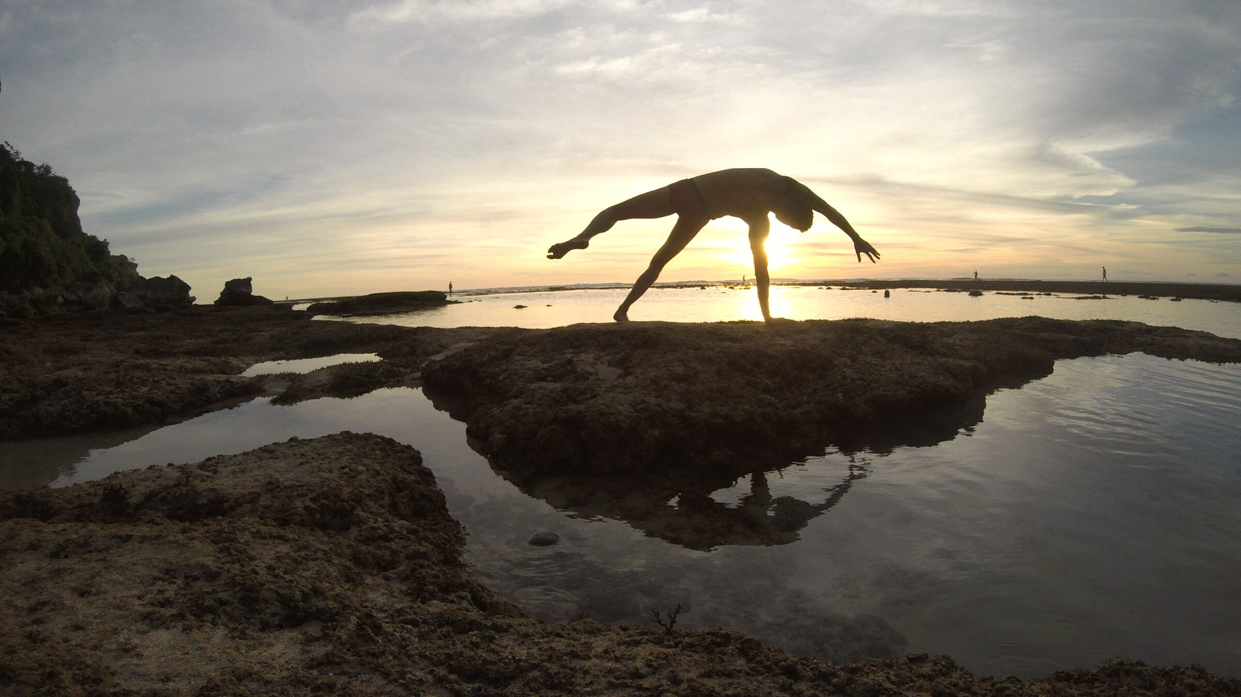 Chris Walker in a backbend against the sunset over the Uluwatu tide pools